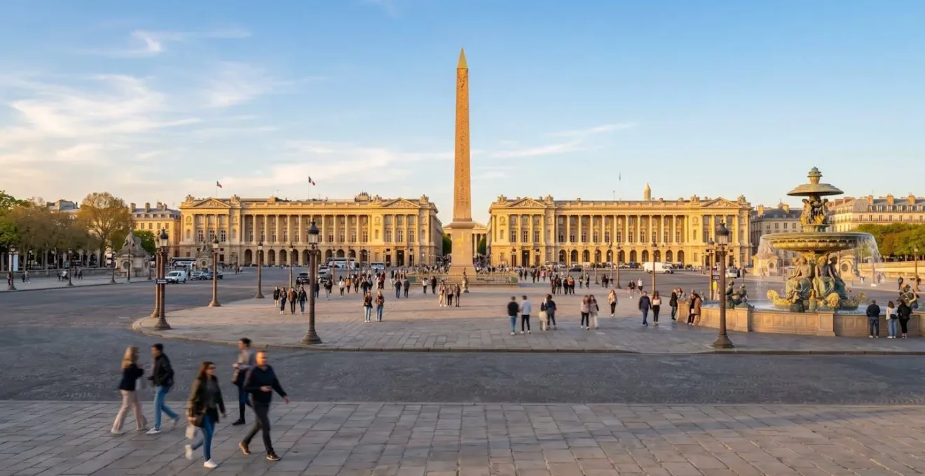 Vue grand angle de la Place de la Concorde au coucher du soleil avec l'Obélisque au centre et des touristes marchant en arrière-plan